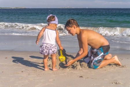 Children building a sand castle at a beautiful beachの写真素材