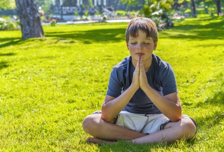 Young boy meditating outdoorsの写真素材