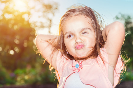 Beautiful little girl posing  outdoors in the summerの写真素材