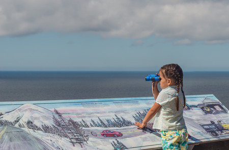 Cute girl looking at the ocean on Cabot Trail look-off (Cape Breton, Nova Scotia, Canada)の写真素材