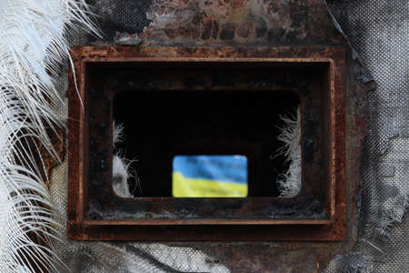 The flag of Ukraine in the viewing window of the destroyed Russian equipment.の写真素材