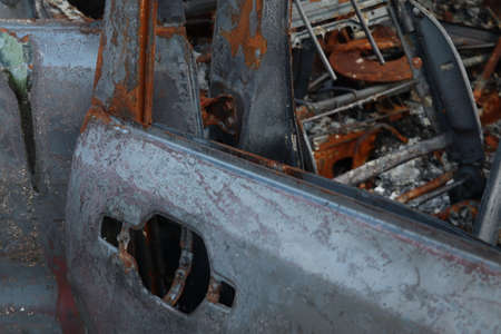 Burnt out passenger car close-up. Damaged vehicles. fire on the road.の写真素材