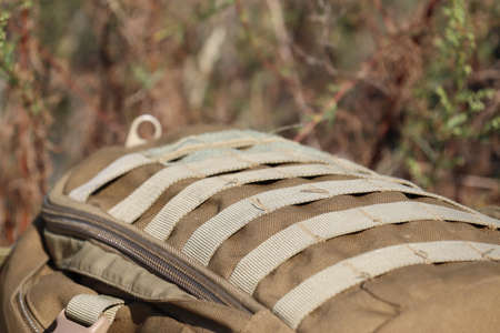 Brown military backpack close-up on the background of nature. Soldier's personal belongings.の写真素材