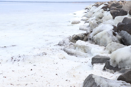 Iced stones on the bank of the river in winter.の写真素材