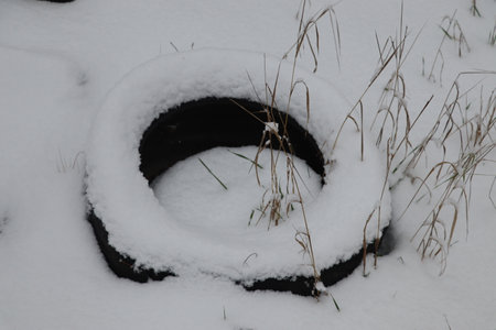 Old tire from a car in the winter in the snow.の写真素材