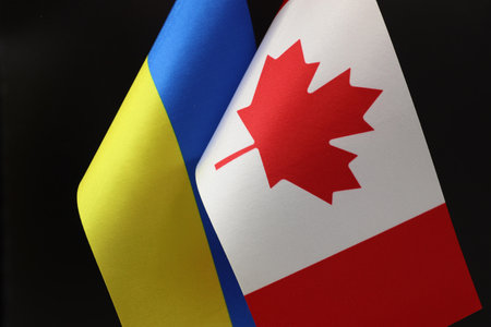 The Ukrainian and Canadian flags waving side by side. A sign of support.の写真素材