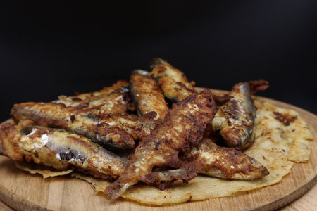 A plate of crispy fried small fish on a wooden board.の写真素材