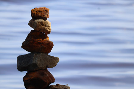 A stack of rocks carefully balanced against a water backdrop.の写真素材