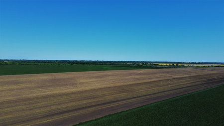 A large field of plowed and unplowed farmland.の写真素材