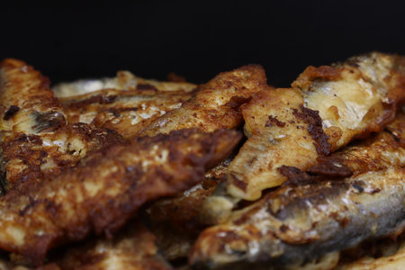 Fried fish with crispy skin and a dark charred texture.の写真素材