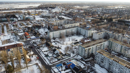 Aerial winter cityscape with snow-covered streets and buildings.の写真素材
