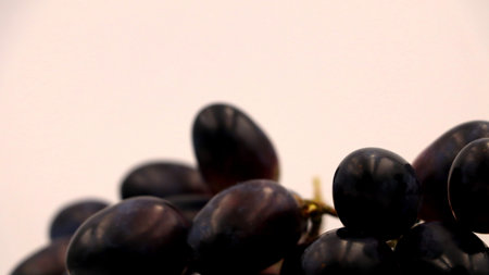 A vibrant close-up captures the rich, dark hues and glossy skins of fresh grapes, artfully arranged...