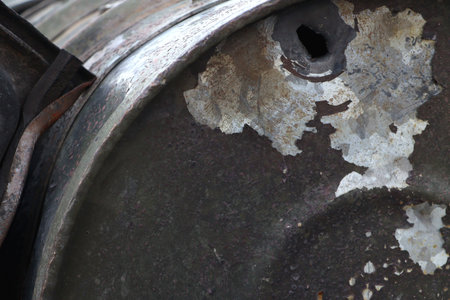A close-up shot reveals a severely damaged and corroded metal barrel, featuring a prominent bullet...