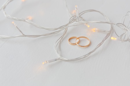 Wedding rings on white wooden floorの写真素材