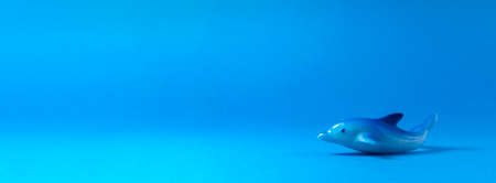 A ceramic dolphin is on a light blue background.の写真素材