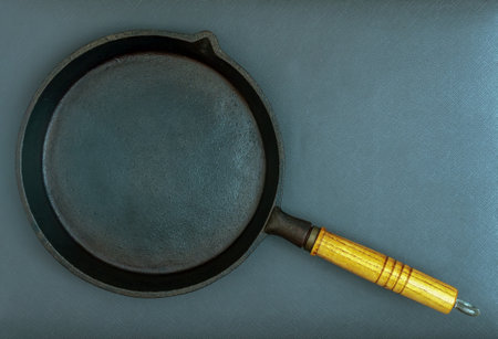 A cast iron frying pan over the dark background.の写真素材