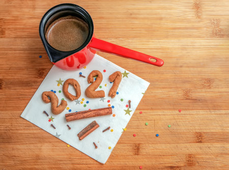 The homemade gingerbread cookiex as 2021 with pieces of cinnamon and cezve of turkish coffee on the...
