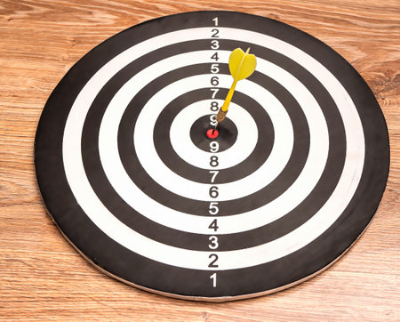 Side view of a dartboard with a dart in the bull's eye. Well-aimed dart throwing.