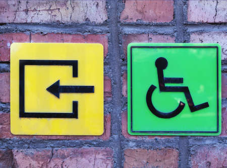 Disabled sign at the entrance on a brick wall, conceptual image.の写真素材