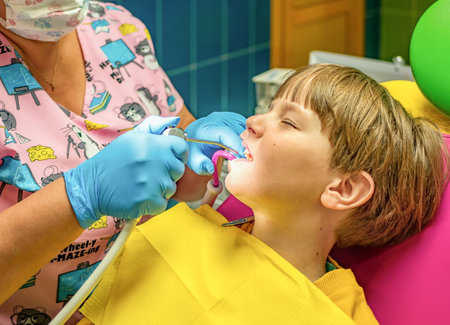 The dentist is carrying out the sanitation of the boy's oral cavity. Children stomatology.の写真素材