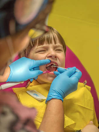 The dentist is carrying out the sanitation of the boy's oral cavity. Children stomatology.の写真素材