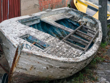 Old abandoned fishing boat lies on the shore.の写真素材