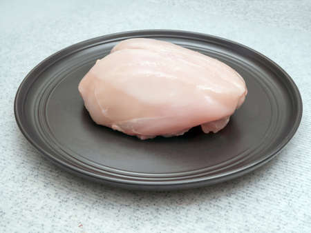 Chicken fillet (white meat) on a black large plateの写真素材