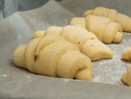 Homemade raw croissants before being sent to the oven on baked sheet. Close-upの写真素材