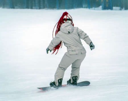 Snowboarder girl is riding a snowboard on the track.の写真素材