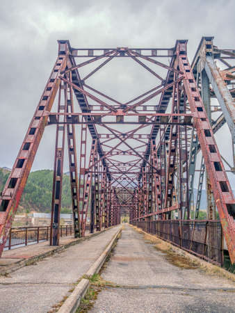 Old steel bridge across the river. Perspective of inside view.の写真素材