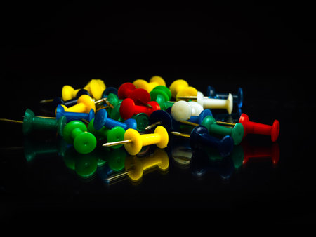Heap of push pin buttons on a black background