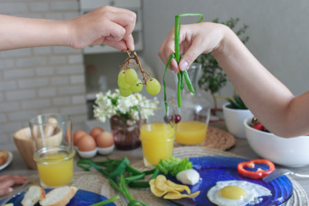 Hands of two people holding food during breakfast.の写真素材