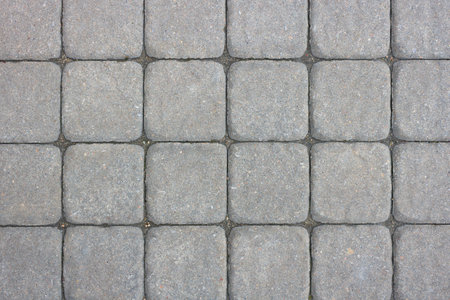 Pavement gray square tiles made of concrete with rounded edges as a background. Background texture of tiled road, floor.の写真素材