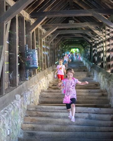 SIGHISOARA, ROMANIA - 1 JULY 2016: Girls running on The Scholars' Stairs, built in 1642 in Sighisoara, Romania.のeditorial素材