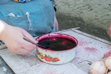 TOCUZ, MOLDOVA - 15 APRIL, 2017: Eggs being painted in for the Easter in a rural area.のeditorial素材