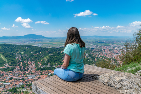 Girl admiring the overview of Brasov city from Tampa mountain in Brasov, Romania.の写真素材