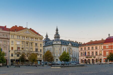 CLUJ-NAPOCA, ROMANIA - October 13, 2018: Cluj-Napoca city center. View from the Unirii Square to the Rhedey Palace and New York Hotel at sunrise on a beautiful, clear sky dayのeditorial素材