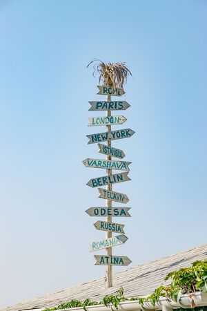 Nessebar, Bulgaria - 7 Sep 2018: Direction signs to different cities in the world on top of a roof in Nesebar ancient city. Nessebar or Nesebr is a UNESCO World Heritage Site.のeditorial素材