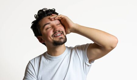 Portrait of a young man with braces smiling. A happy young man with braces on a white background.の写真素材