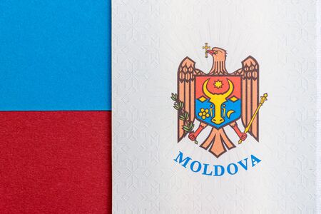 Republic of Moldova concept. The Moldovan passport on a blue and red background. Coloseup of the emblem/coat of arms of Moldova. Moldova Finance and economy concept.の写真素材