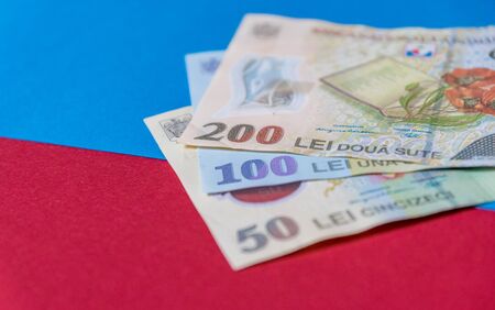 Romanian banknotes on a blue and red background. Coloseup of RON, Romanian Currency. Romanian RON,...