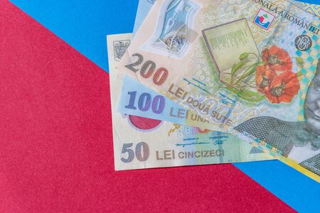 Romanian banknotes on a blue and red background. Coloseup of RON, Romanian Currency. Romanian RON, Lei Banknotes issued by BNR, National Bank of Romania. Romania Finance and economy concept.の写真素材