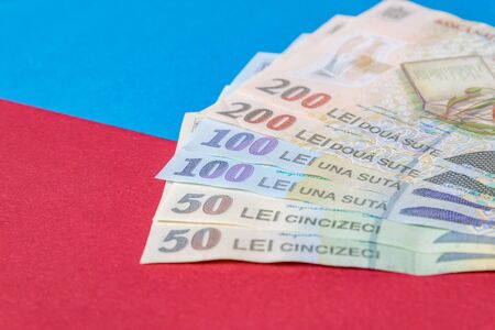 Romanian banknotes on a blue and red background. Coloseup of RON, Romanian Currency. Romanian RON, Lei Banknotes issued by BNR, National Bank of Romania. Romania Finance and economy concept.の写真素材