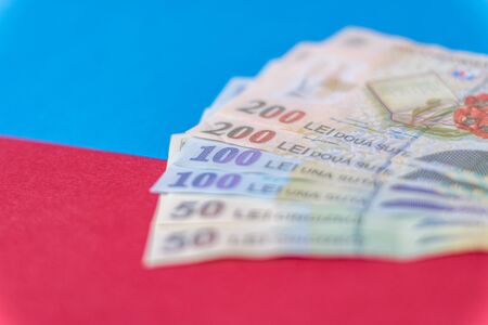 Romanian banknotes on a blue and red background. Coloseup of RON, Romanian Currency. Romanian RON, Lei Banknotes issued by BNR, National Bank of Romania. Romania Finance and economy concept.の写真素材