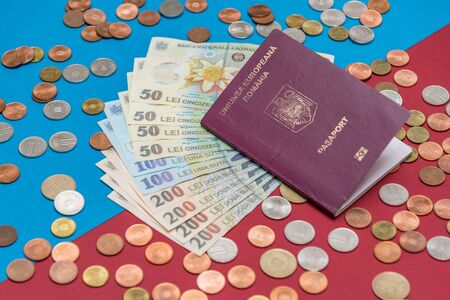 Romanian concept. The Romanian passport and Romanian banknotes/coins on a blue and red background. Coloseup of Romanian Passport and Romanian currency. Romania Finance and economy concept.の写真素材