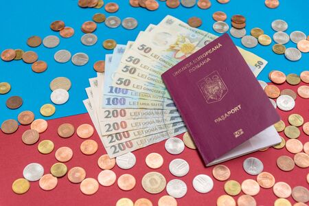 Romanian concept. The Romanian passport and Romanian banknotes/coins on a blue and red background. Coloseup of Romanian Passport and Romanian currency. Romania Finance and economy concept.の写真素材