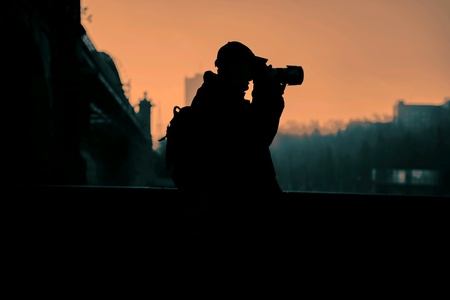Photographer figure  on the sunset sky near the bridgeの素材