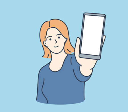 Online communication, smartphone screen. Young smiling woman showing smartphone screen with white mockup for text or lettering.のイラスト素材