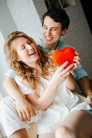 Couple in love watches a gift heart box on Valentines day.の写真素材