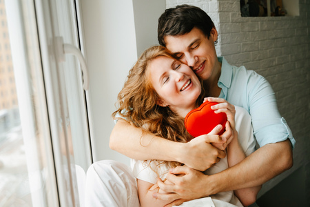 Couple in love watches a gift heart box on Valentines day.の写真素材